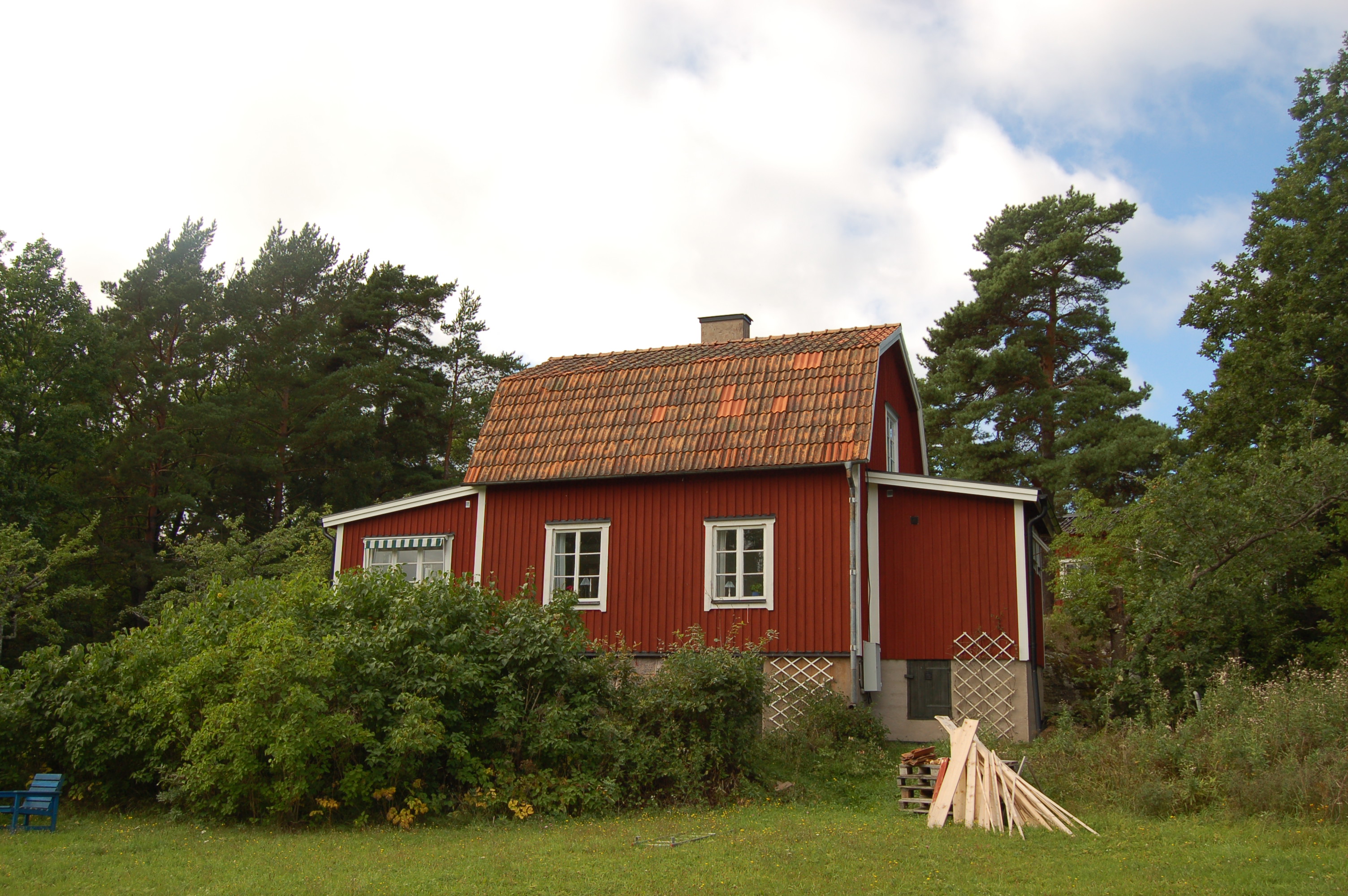 Bostadshus med omgivande trädgård.