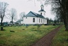 Östra Frölunda kyrka med omgivande begravningsplats sedd från nordöst.