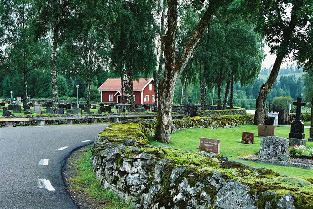 Till höger den äldre kyrkogårdelen belägen närmast kyrkan och till vänster om landsvägen, den yngre kyrkogårdsdelen söder om kyrkan.


