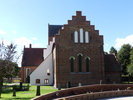 Åhus kyrka från öster med korväggen närmast. I förgrunden minneslunden på kyrkogårdens östra del.