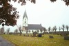 Hyssna kyrka med omgivande begravningsplats sedd från söder.