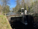 Dammen har två öppningar varav en är fjärrmanövrerad. Bilden visar en betydande 
nivåskillnad på vattnet i kanalen uppströms och nedströms dammluckorna. 