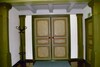 Långhusets entréparti under läktaren med en dörr in till sakristian i Tämta kyrka till höger i bild.