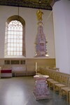 Caroli kyrkas dopfunt och fönster, samt väggpanel med bänkar.