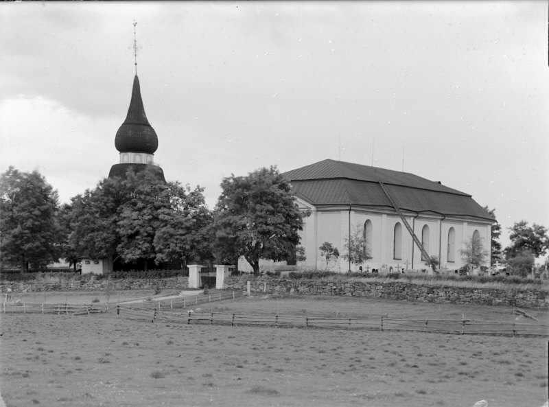 Ovanåkers kyrka och klockstapeln från sydväst.