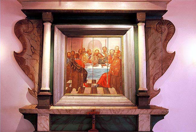 Altaruppsatsen, som härstammar från Askums gamla kyrka, med Christian von Schönfelts nattvardsmålning. Uppdraget i Askums kyrka 1738, som omfattade altaruppsats, predikstol mm samt att måla hela innertaket, var hans sista kända uppdrag. Han avled 1742, drygt åttio år gammal.