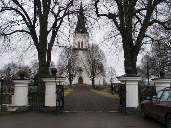 Kyrkan och kyrkogården från kyrkvallen i väster. 