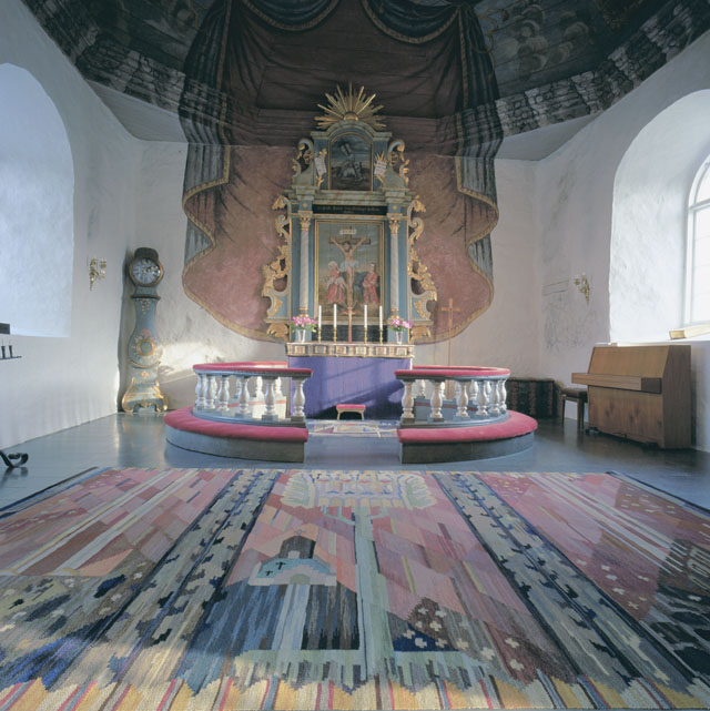 Koret med draperimålad östvägg. Mattan i förgrunden är tillverkad av Anna Maria Hoke, textilkonstnär.
