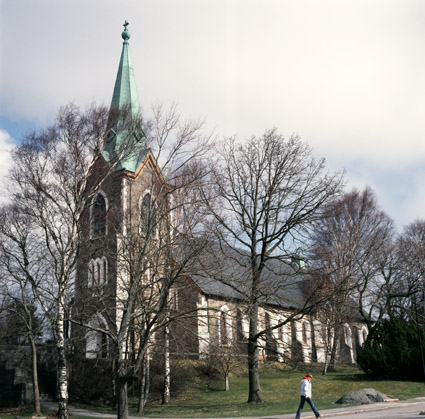 Den södra fasaden. Kyrkotomtens murar, trappor och uppvuxna lövträd är värdefulla för kyrkomiljöns karaktär. 