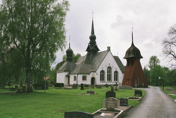 Lerums kyrka och klockstapel med omgivande kyrkogård, från NÖ.