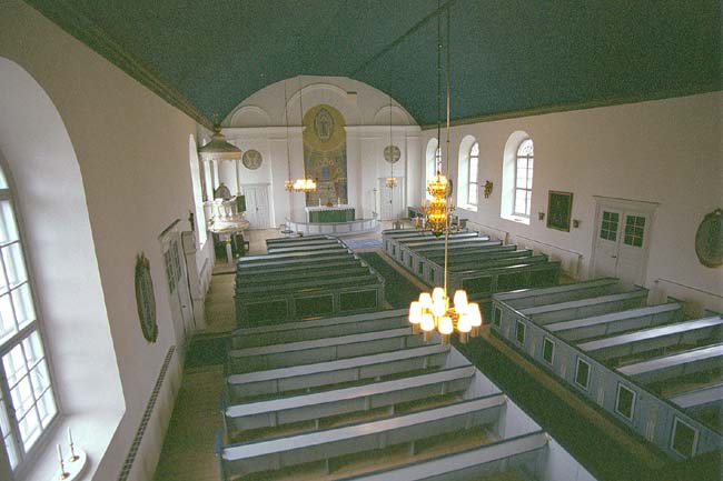 Kyrkorummet sett mot koret i öster från orgelläktaren i väster.