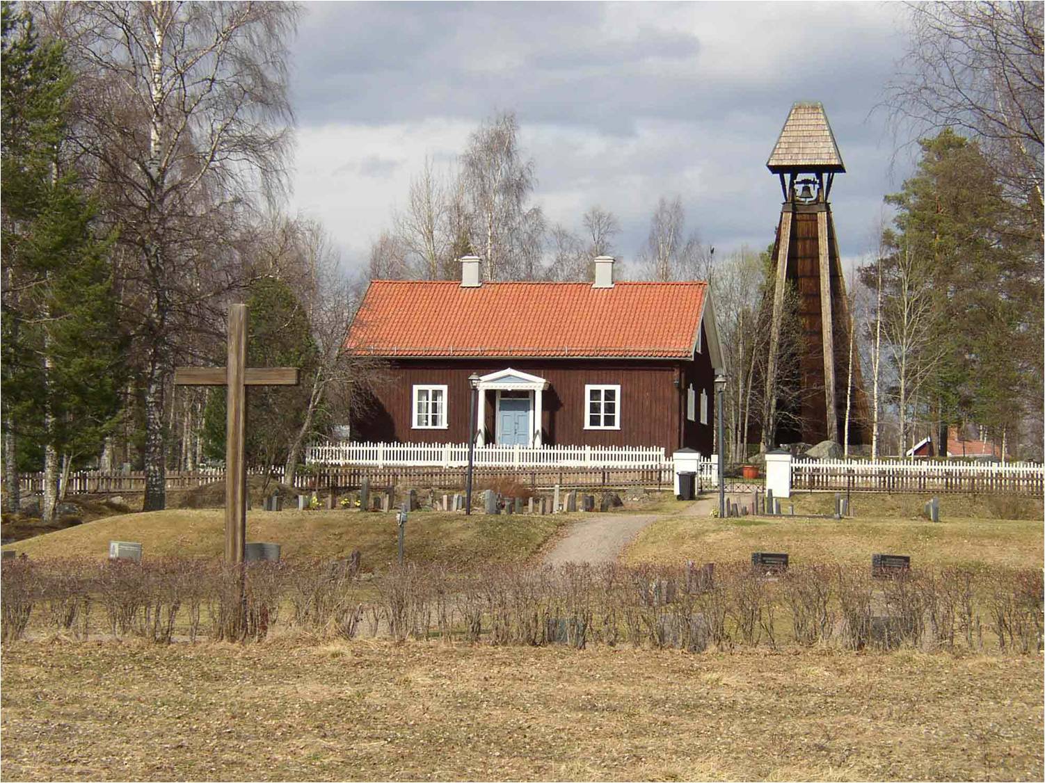 Kyrkomiljön i Fågelsjö med kyrkogården i förgrunden och kapellet och klockstapeln i bakgrunden. 