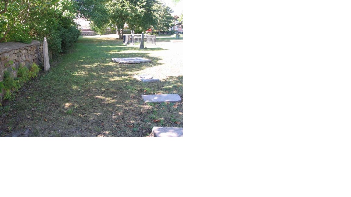 Del av kyrkogårdens omgärdning i väster.